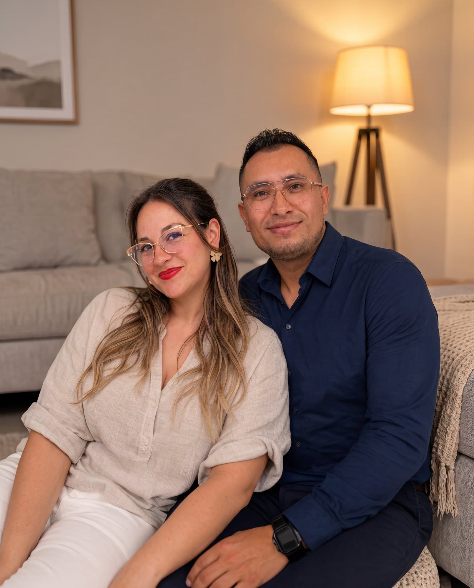 Jason Ortega y Johanna Herrera en la sala de su casa, con luz cálida de lámpara.